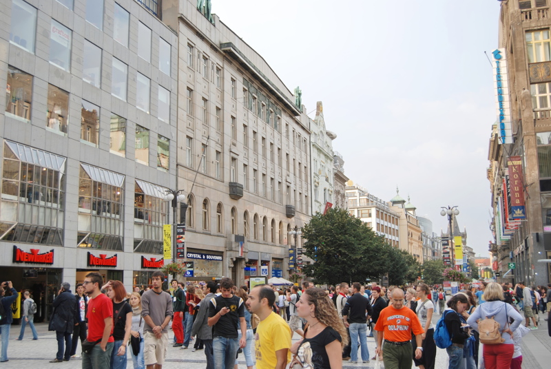 1 - A busy pedestrian shopping street, likely Wenceslas Square in Prague, Czech Republic